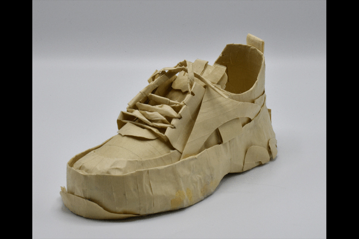 A masking tape shoe replica on a white background